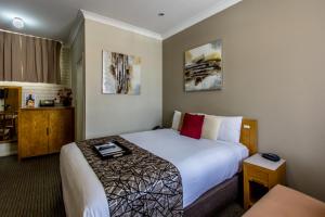 a hotel room with a bed and a table at Best Western Endeavour Motel in Maitland