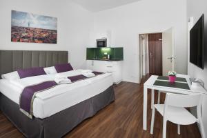 a bedroom with a bed and a table and a kitchen at Elizabeth Suites in Prague