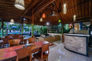 a restaurant with a table and chairs and a bar at Taos House Nusa Lembongan by Best Deals Asia Hospitality in Nusa Lembongan