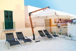a group of chairs and an umbrella on a patio at B & B Sotto la Volta in Massafra
