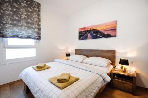 1 dormitorio con 1 cama con 2 toallas en Sea view Tiho Apartment en Split
