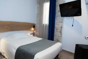 a bedroom with a bed and a flat screen tv at Hostal Paris in Barcelona