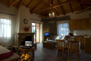 a kitchen and living room with a table and a fireplace at Mouses Apartments-Kardamyli in Kardamyli