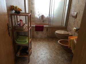 ein Badezimmer mit einer Badewanne, einem WC und einem Waschbecken in der Unterkunft Haus Falger in Berwang