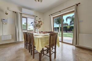 a dining room with a table and chairs and a window at Villa Eva in Ayia Napa