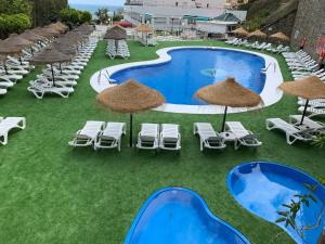 an overhead view of a resort pool with chairs and umbrellas at First Flatotel International in Benalmádena