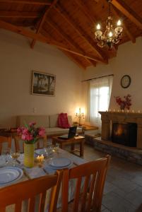 Una sala de estar con una mesa y una chimenea. en Mouses Apartments-Kardamyli, en Kardhamili