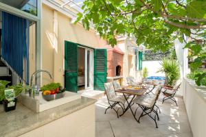 Un patio al aire libre con una mesa y sillas y un fregadero. en Villa Corona Split, en Split