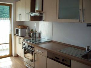 uma cozinha com um lavatório e um fogão forno superior em Ferienwohnung Brunner em Grafenau