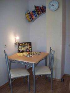 a table with two chairs and a clock on the wall at Ferienwohnung Brunner in Grafenau