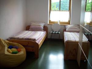 a room with two beds and a chair in it at Ferienwohnung Brunner in Grafenau