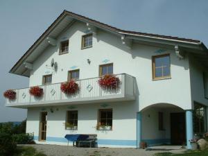 a white building with flower boxes on the balcony at Ferienwohnung Brunner in Grafenau