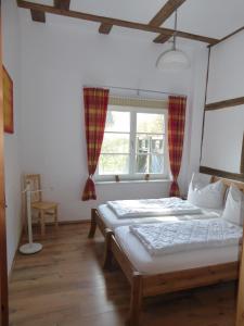 a bedroom with two beds and a window at Ferienwohnung Ostseewald in Rostock