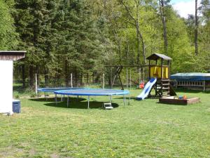 a playground with a blue and yellow trampoline at Ferienwohnung Ostseewald in Rostock