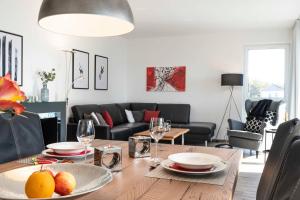 a dining room with a table with plates and wine glasses at Appartement Schilfperle - Oase am Haff in Garz-Usedom