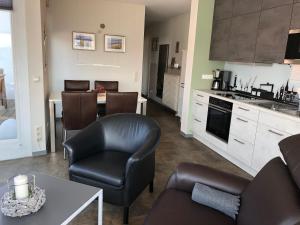 a kitchen and living room with chairs and a table at Haus Meeresblick Whg. 4.11 in Kühlungsborn +7 photos