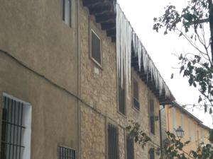 a close up of a brick building with windows at 1 P Casa de los Fernandez Rajo in Orihuela del Tremedal