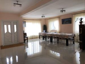 a dining room with a table and chairs on the floor at Casa Banc in Baile Unu Mai
