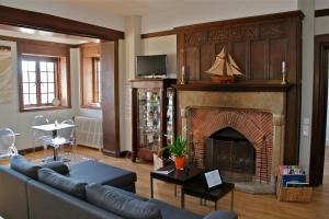 a living room with a couch and a fireplace at Manoir Dalmore in Névez