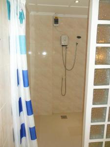 y baño con ducha y cortina de ducha. en Jasmin's Room Rental en Moalboal