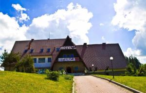 hotel na trawiastym wzgórzu z budynkiem w obiekcie Hotel Restauracja U Guta w mieście Klikuszowa