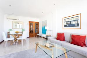 een witte woonkamer met een witte bank en rode kussens bij Rooms & Suites Balcony 3D in Arrecife