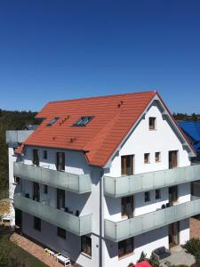 un edificio de apartamentos con techo rojo en Izba u Jędrusia en Karwia