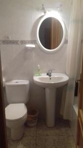 a bathroom with a toilet and a sink and a mirror at Casas Valleiruelas in Las Cruceras +13 photos