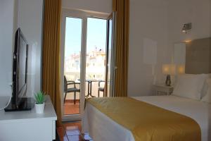 ヴィラ・ノヴァ・デ・ミルフォンテスにあるFlats - Duna Parque Groupのベッド1台付きのホテルルームで、バルコニーが付いています。