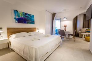 a bedroom with a large white bed and a living room at Villa Katarina in Makarska