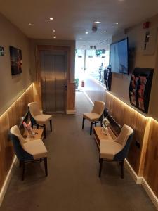 a waiting room with chairs and tables and a tv at 9a Craven Road in London