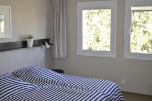 a bedroom with a bed and two windows at Haus Störtebeker in Ahlbeck