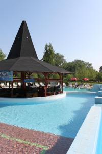 a swimming pool with a gazebo in the middle at Aqua Land Villapark in Ráckeve