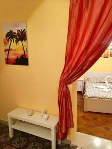 シッラにあるAppartamento nel cuore di Scillaの赤いカーテンとベッドが備わる客室です。