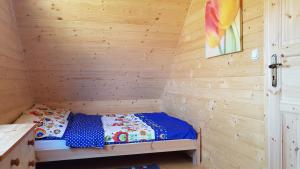 a small room with a bed in a wooden cabin at Niebieski Zakątek in Wisełka