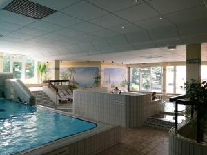 a large swimming pool with a pool slide in a building at Top Appartment mit Weitblick und Late Check-Out inklusive aktivCARD in Sankt Englmar