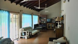 ein Wohnzimmer mit einem Sofa und einem Stuhl in der Unterkunft TERRAZA AL RIO 2 in Paso de la Patria