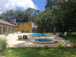 einen Hinterhof mit einem Pool mit Stühlen und einem Schlauch in der Unterkunft TERRAZA AL RIO 2 in Paso de la Patria