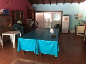 a kitchen with a blue table and a refrigerator at TERRAZA AL RIO 2 in Paso de la Patria