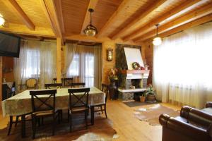 Una sala de estar con mesa y sillas y una chimenea. en Villa Monte, en Slavske