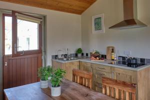 a kitchen with a sink and a table with chairs at Middlewick Holiday Cottages in Glastonbury +85 photos