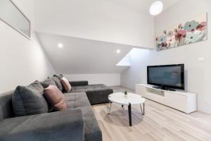 a living room with a couch and a flat screen tv at GREY Apartment Old Town in Zadar