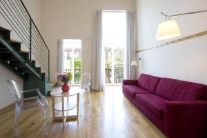a living room with a purple couch and a table at Hotel Piazza Bellini & Apartments in Naples