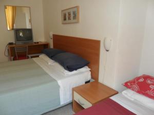 Habitación de hotel con 2 camas y TV en Albergo Romeo, en Noli
