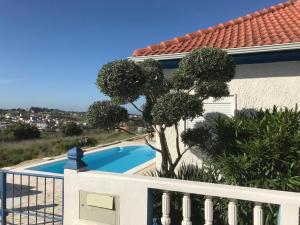 uma vista para uma piscina a partir de uma varanda de uma casa em Vivenda da bela vista em Costa da Caparica