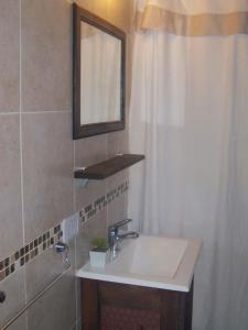 a bathroom with a sink and a mirror and a shower at Departamento Piedra del Condor in San Carlos de Bariloche