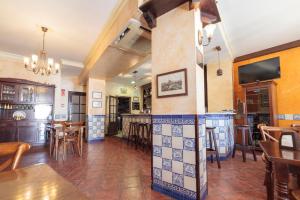 Cette grande chambre dispose d'un bar avec des chaises et des tables. dans l'établissement Casa Palacio de los Leones, à El Puerto de Santa María