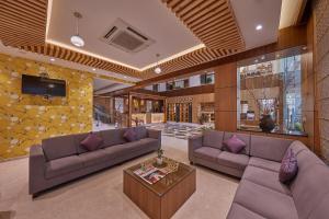 ein Wohnzimmer mit 2 Sofas und einem Tisch in der Unterkunft Shivas Galaxy Hotel in Devanhalli