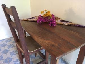 una mesa de madera con un arreglo floral encima en Guesthouse Yonol en Abémé