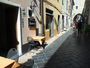 una calle con mesas y gente caminando por una calle en Albergo Romeo, en Noli